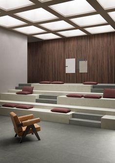 an empty lecture hall with benches and mirrors