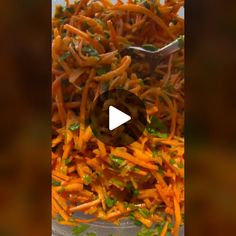 a bowl filled with shredded carrots and green onions