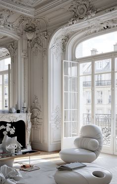 a living room filled with white furniture and large windows