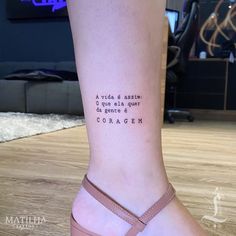 a woman's foot with a quote tattooed on the lower part of her leg