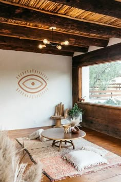 a living room with wooden floors and white walls, an eye drawn on the wall