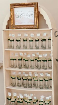 there is a shelf with many jars on it and a framed sign above the shelves