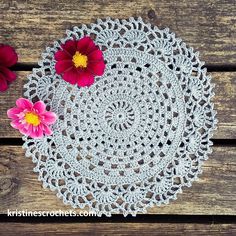 crocheted doily with pink flowers on wooden table top, ready to be used as placemats