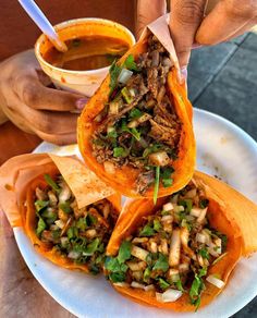 three burritos filled with meat and veggies on top of a white plate