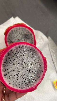 two pieces of fruit that are sitting on top of a paper towel and someone is holding it in their hand