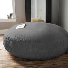 a large round gray pillow sitting on top of a wooden floor