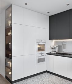 a kitchen with white cabinets and black counter tops, along with an oven in the center