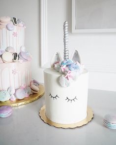 two cakes decorated with unicorn themed icing on top of a table next to each other