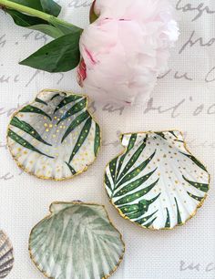 three plates with leaves on them next to a pink peonie and white carnation