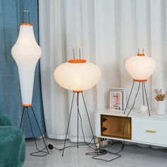 three floor lamps sitting on top of a white table