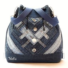 a handbag made out of denim with straps and buttons on the front, sitting on a white surface