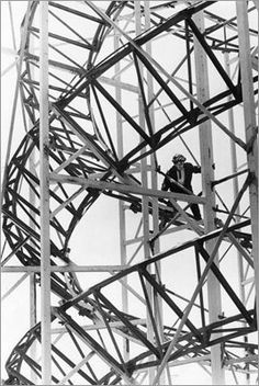 black and white photograph of a man on skis in the middle of a metal structure