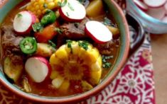 a bowl filled with stew and vegetables on top of a table