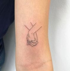 a couple of hands holding each other on the wrist tattoo designs for men and women