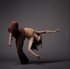 a woman is doing a handstand in the air with her arms stretched out