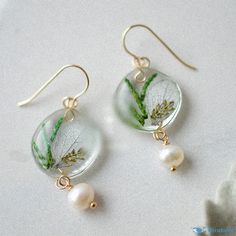 the earrings are decorated with leaves and pearls