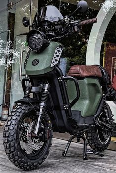 a green motorcycle parked in front of a building