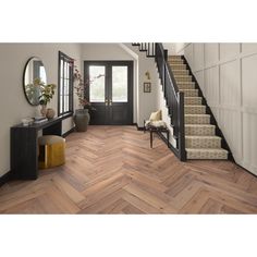 an entryway with stairs and wooden flooring next to a mirror on the wall