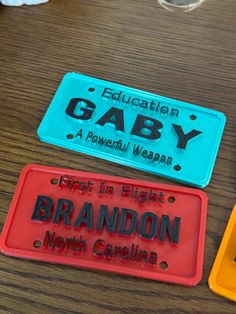 three license plates sitting on top of a wooden table next to a cup and saucer