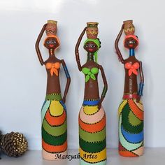 three wooden figurines are standing next to each other