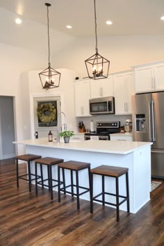 a kitchen with an island and four stools in front of the stove top oven