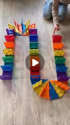 a child playing with colorful plastic blocks on the floor