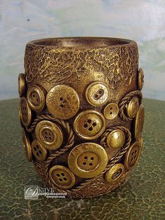 a close up of a vase on a table with buttons in the middle and holes in the bottom