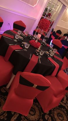 a banquet room set up with black and red linens