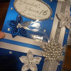 a blue and silver card with flowers on it