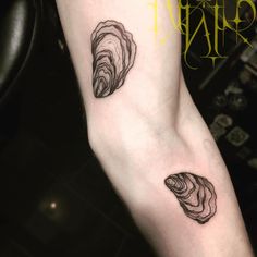 two black and white tattoos on the legs of someone's leg, one with a shell in it