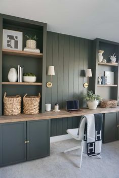 an office with green painted walls and open shelvings on the wall, along with wicker baskets