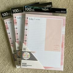 three pink and white planner pages sitting on top of each other in front of a pile of papers