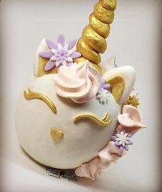 a cake shaped like a unicorn's head with gold horn and flowers on it