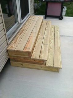 a wooden bench sitting on the side of a house