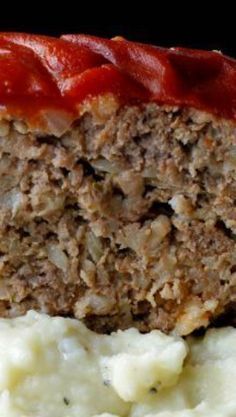 meatloaf with mashed potatoes and ketchup on a black background, close up