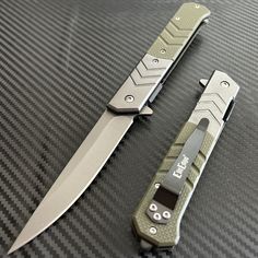 two knives sitting on top of a table with black and green trimmings next to each other