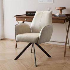 a chair sitting on top of a wooden floor next to a desk with a lamp