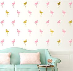 pink flamingo wall decals on a white wall in a living room with a blue couch