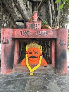 there is a small shrine with a buddha statue in the center and trees around it