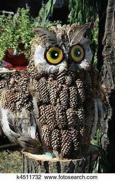 an owl sitting on top of a tree stump with large yellow eyes and brown feathers