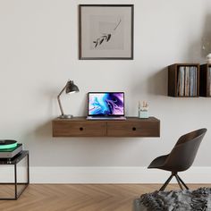 a laptop computer sitting on top of a wooden desk next to a chair and bookshelf