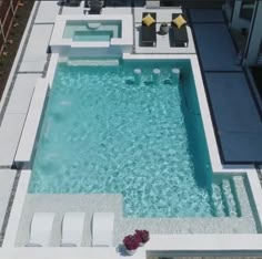 an aerial view of a swimming pool with lounge chairs