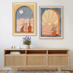 two paintings hang on the wall above a wooden cabinet with flowers and plants in it