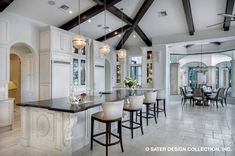 a large kitchen with white cabinets and black counter tops, along with an island in the middle