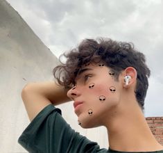 a young man with his hair styled to look like birds on his face and ear