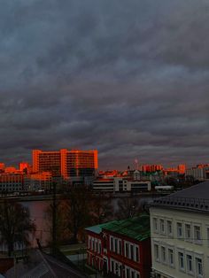 the city skyline is lit up at night with orange lights on it's buildings