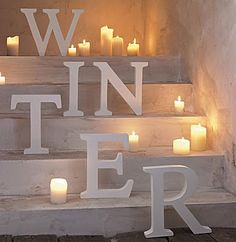 candles are lit up on the steps in front of a sign that reads, w inn fer