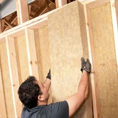 a man is working on framing the walls