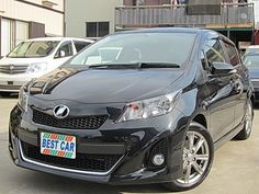 a black car parked in a parking lot next to other cars