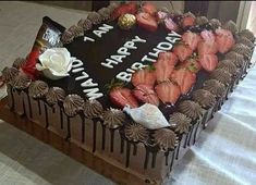 a birthday cake with strawberries and chocolate frosting